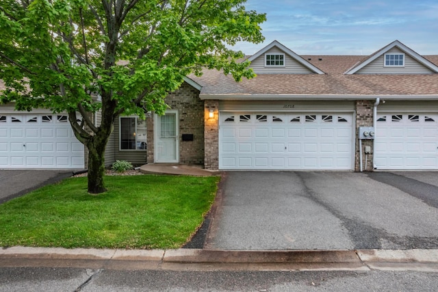 10708 Sycamore St NW, Coon Rapids, MN 55433 - view of front facade featuring roof with shingles, brick siding, asphalt driveway, and a front yard
