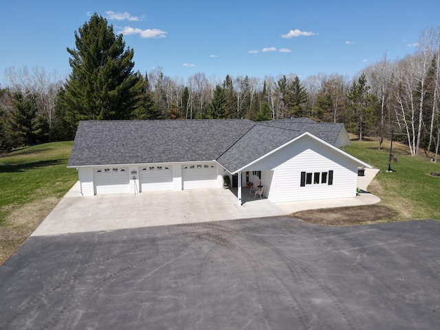 ranch-style house with driveway, a front yard, roof with shingles, and an attached garage