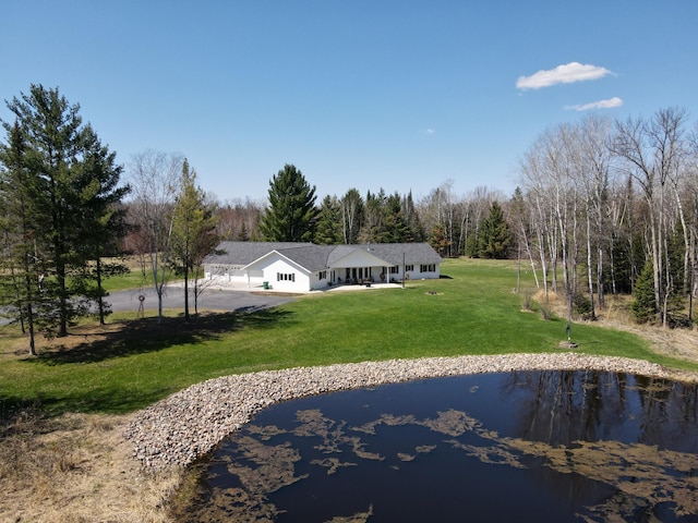 view of front of home with a water view, a front yard, and a wooded view