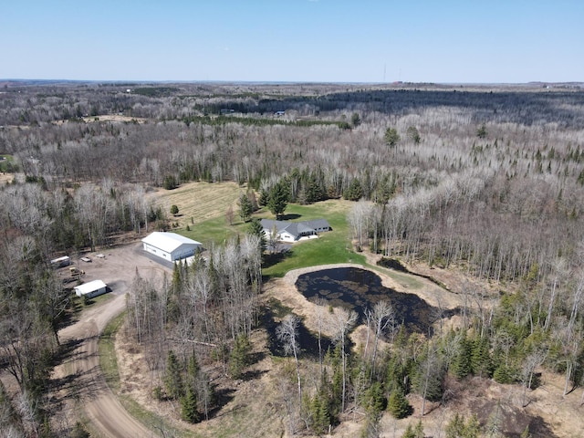 aerial view of property and surrounding area with a heavily wooded area