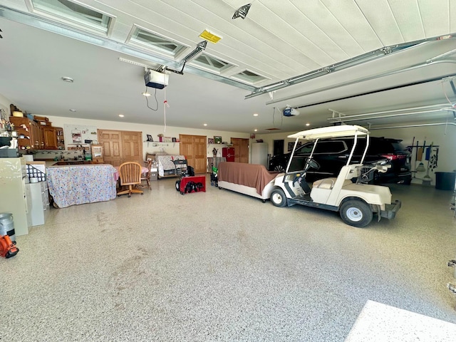 garage with a garage door opener and recessed lighting