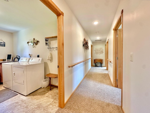 laundry room featuring washing machine and clothes dryer, light carpet, and baseboards