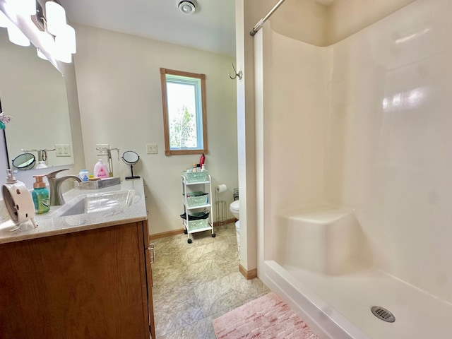 full bathroom featuring a shower stall, toilet, baseboards, and vanity