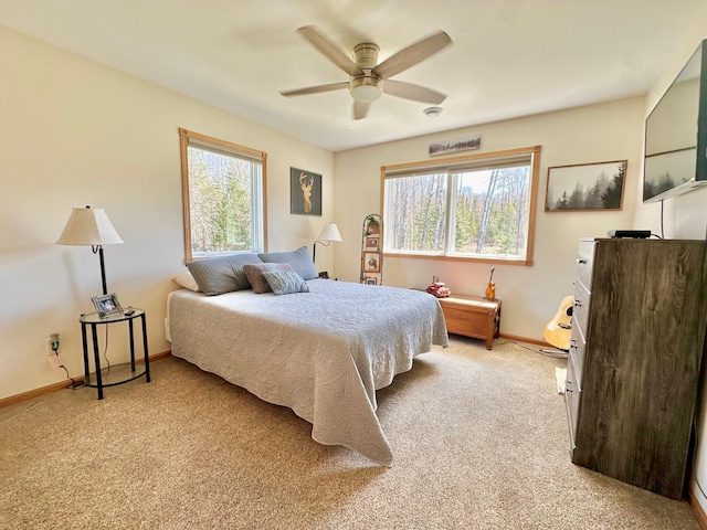 bedroom with light carpet, baseboards, and a ceiling fan