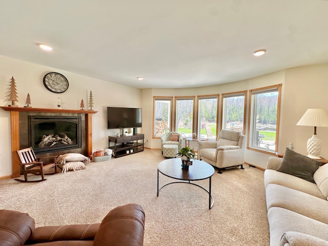 living area with carpet flooring, a glass covered fireplace, recessed lighting, and baseboards