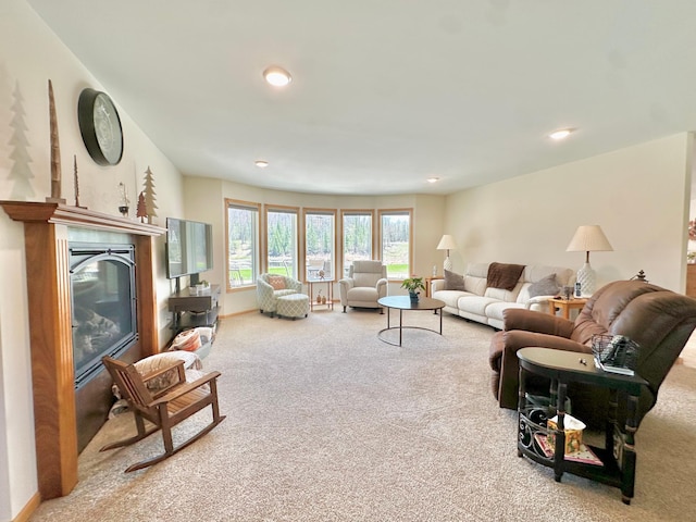 living area featuring carpet flooring, recessed lighting, and a glass covered fireplace