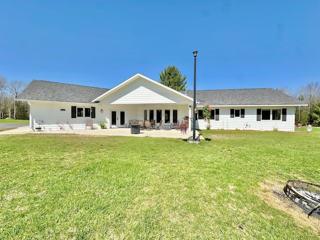 rear view of house with french doors, a yard, and a patio area
