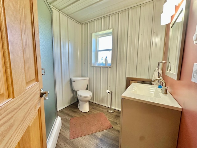 full bathroom with wood finished floors, toilet, a shower, vanity, and baseboards