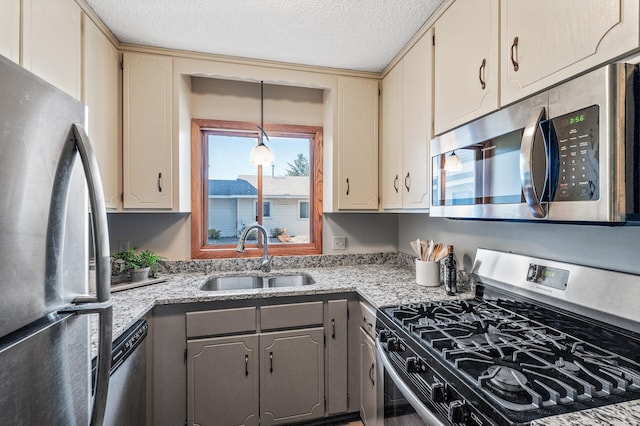 11123 Drake St NW, Coon Rapids, MN 55433 - kitchen with stainless steel appliances, a sink, gray cabinetry, a textured ceiling, and light stone countertops