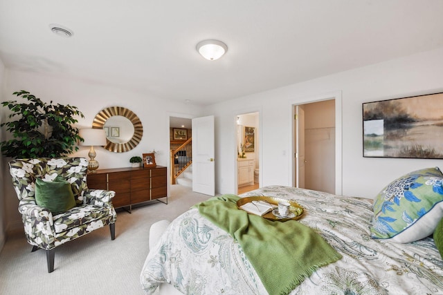 carpeted bedroom with a walk in closet, a closet, and ensuite bathroom