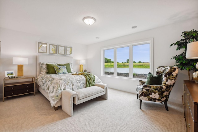 bedroom with light carpet and a water view