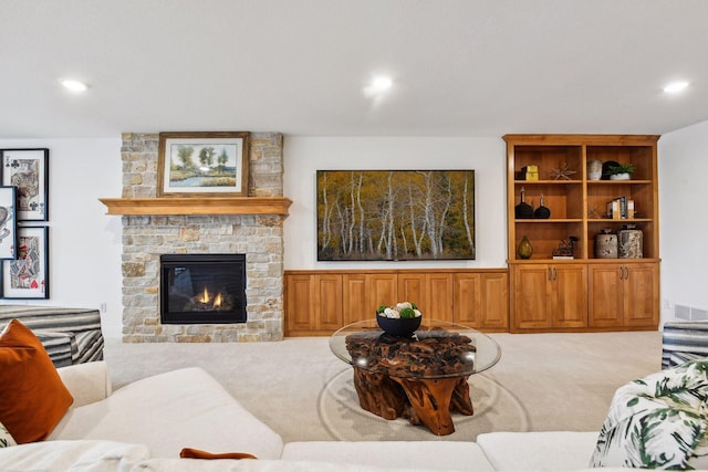 carpeted living area featuring a stone fireplace and recessed lighting