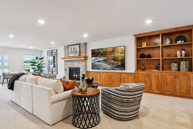 living area with light carpet, a stone fireplace, and recessed lighting