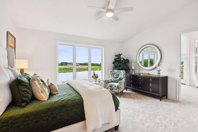 bedroom featuring multiple windows, carpet floors, vaulted ceiling, a water view, and ceiling fan