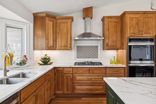 kitchen with appliances with stainless steel finishes, a sink, and light stone counters