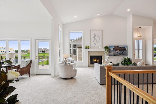 living room featuring carpet flooring, vaulted ceiling, a glass covered fireplace, and recessed lighting