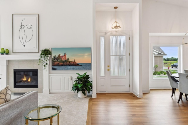 entrance foyer featuring wood finished floors, a tile fireplace, and baseboards