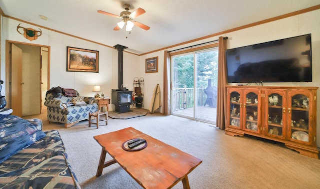 living area with crown molding, carpet floors, a wood stove, a ceiling fan, and lofted ceiling