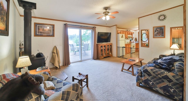 living room with carpet floors, a ceiling fan, a wood stove, and crown molding