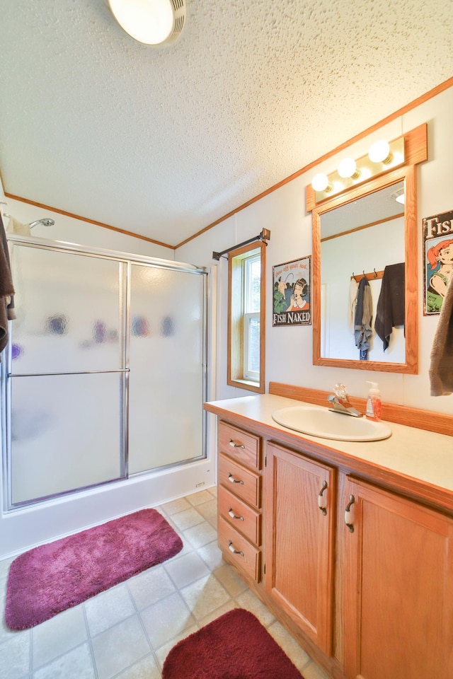 bathroom featuring crown molding, an enclosed shower, vanity, a textured ceiling, and tile patterned flooring
