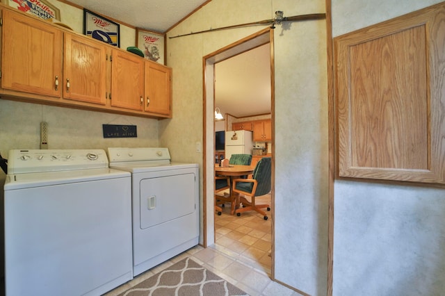 clothes washing area featuring washing machine and dryer, cabinet space, and light tile patterned flooring