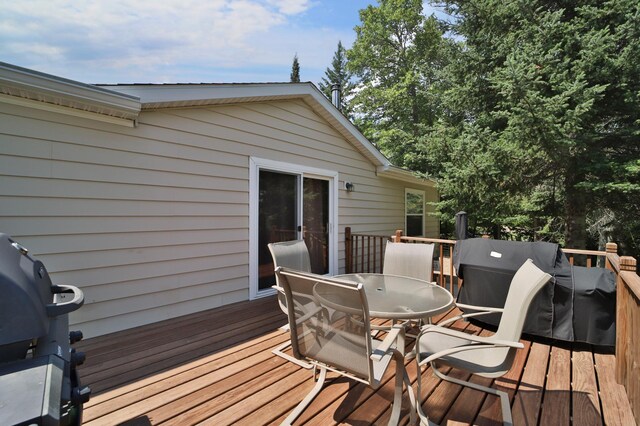 deck with outdoor dining space and grilling area