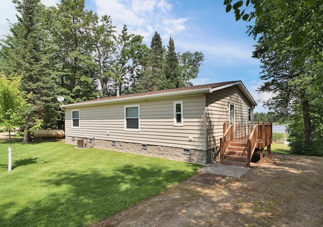 view of side of property with crawl space, a lawn, and central AC