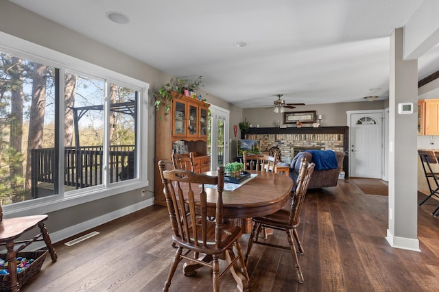 27088 130th St, Thomastown Twp, MN 56479 - dining room featuring a brick fireplace, ceiling fan, dark wood-style floors, baseboards, and healthy amount of natural light