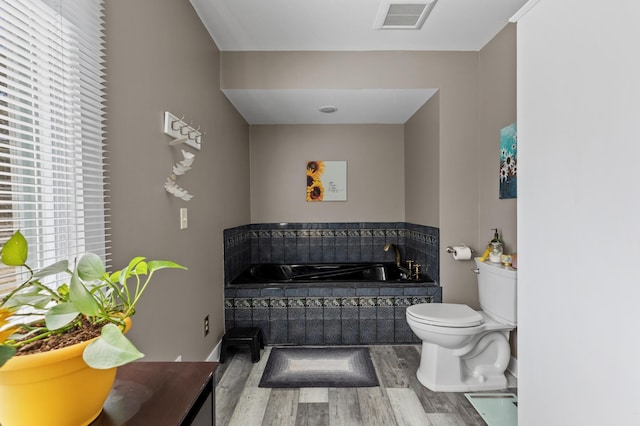 27088 130th St, Thomastown Twp, MN 56479 - bathroom featuring wood finished floors, a bath, and toilet
