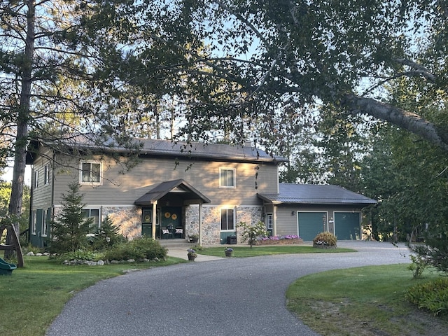 27088 130th St, Thomastown Twp, MN 56479 - view of front of property featuring a garage, a front yard, curved driveway, and stone siding