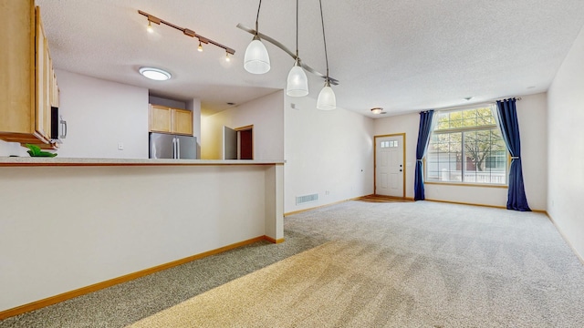 kitchen with stainless steel appliances, a textured ceiling, carpet flooring, baseboards, and pendant lighting