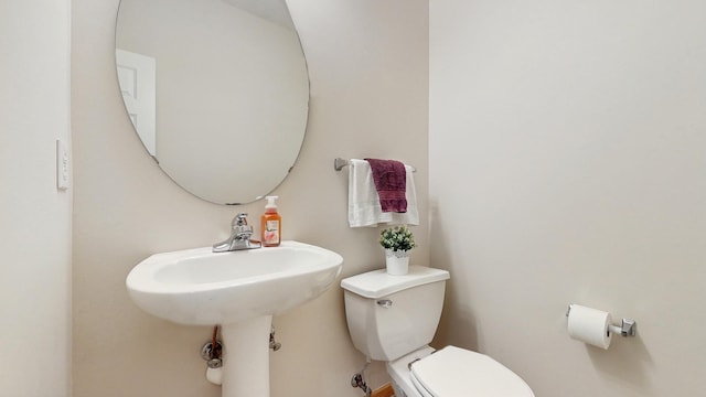 half bathroom featuring toilet and a sink