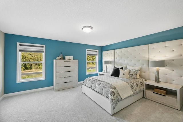 carpeted bedroom with multiple windows and baseboards