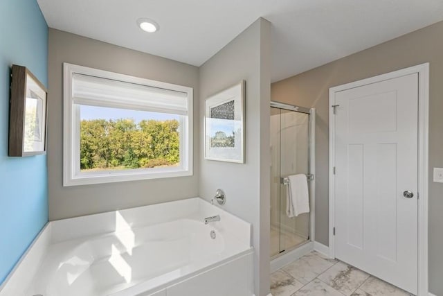 bathroom with a shower stall, a bath, and marble finish floors