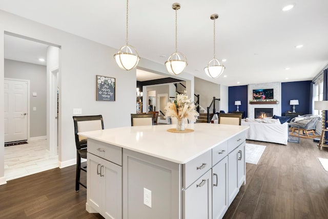 13404 Avila Ave, Rosemount, MN 55068 - kitchen featuring a fireplace, a kitchen breakfast bar, a kitchen island, dark wood-type flooring, and recessed lighting