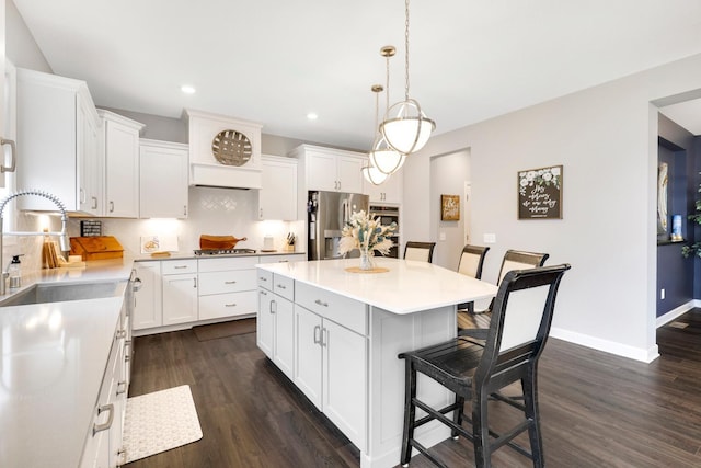 13404 Avila Ave, Rosemount, MN 55068 - kitchen with appliances with stainless steel finishes, a sink, a kitchen bar, dark wood-style flooring, and decorative backsplash