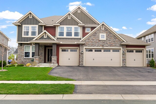 13404 Avila Ave, Rosemount, MN 55068 - craftsman house with board and batten siding, asphalt driveway, a front lawn, and stone siding