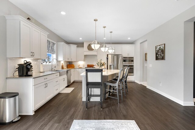 13404 Avila Ave, Rosemount, MN 55068 - kitchen featuring appliances with stainless steel finishes, dark wood-type flooring, white cabinetry, a breakfast bar area, and recessed lighting