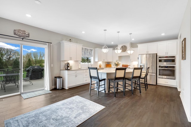 13404 Avila Ave, Rosemount, MN 55068 - kitchen with appliances with stainless steel finishes, recessed lighting, white cabinetry, a kitchen island, and dark wood-style flooring