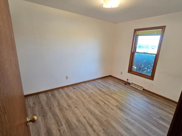 735 10th Ave S, Waite Park, MN 56387 - unfurnished room featuring wood finished floors, baseboards, and a textured ceiling