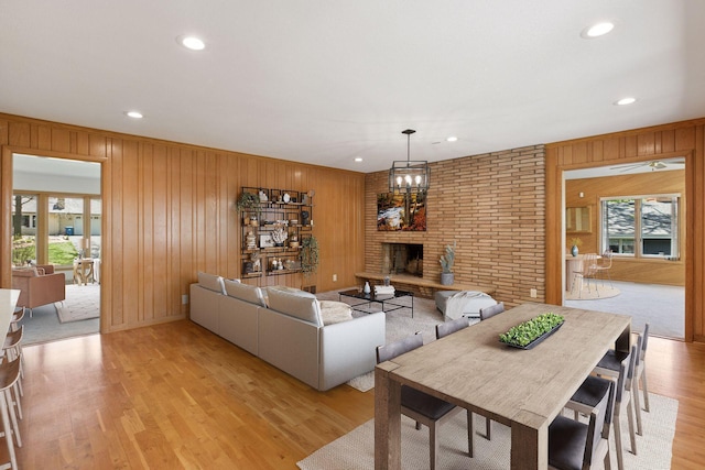 5212 Colonial Dr, Golden Valley, MN 55416 - living room featuring healthy amount of natural light, wood walls, light wood finished floors, a brick fireplace, and recessed lighting