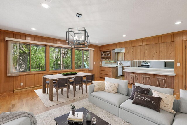 5212 Colonial Dr, Golden Valley, MN 55416 - living area featuring wooden walls, light wood-style floors, a chandelier, baseboard heating, and recessed lighting