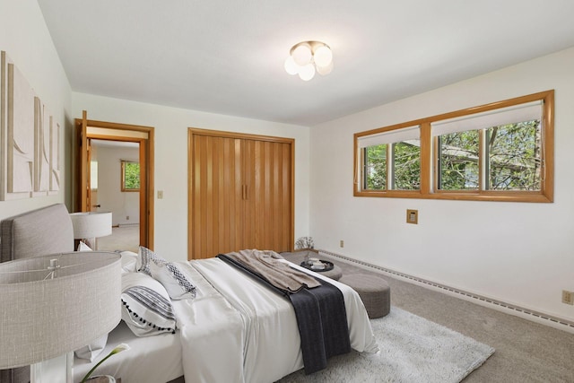 5212 Colonial Dr, Golden Valley, MN 55416 - carpeted bedroom featuring multiple windows, a closet, a baseboard heating unit, and baseboards