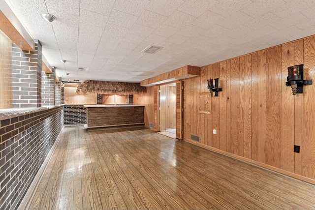 5212 Colonial Dr, Golden Valley, MN 55416 - unfurnished living room featuring hardwood / wood-style flooring, wooden walls, and baseboards