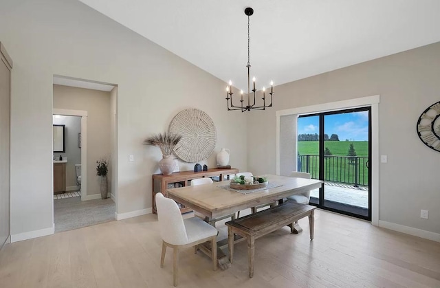 dining room with light wood-type flooring, a chandelier, and baseboards