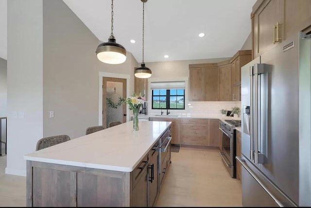 kitchen featuring high quality appliances, a sink, tasteful backsplash, a kitchen island, and hanging light fixtures