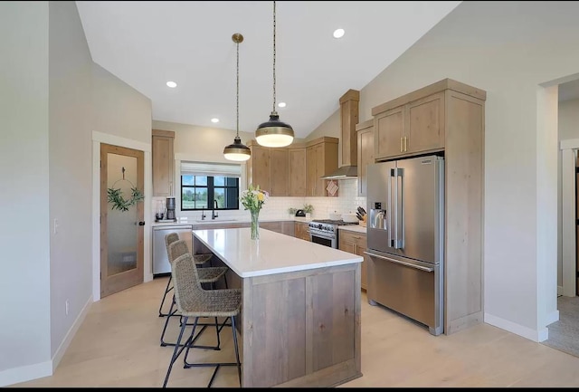 kitchen featuring premium appliances, a sink, wall chimney exhaust hood, tasteful backsplash, and lofted ceiling