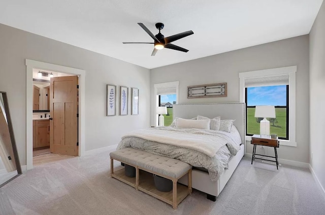 bedroom featuring light carpet, baseboards, and multiple windows