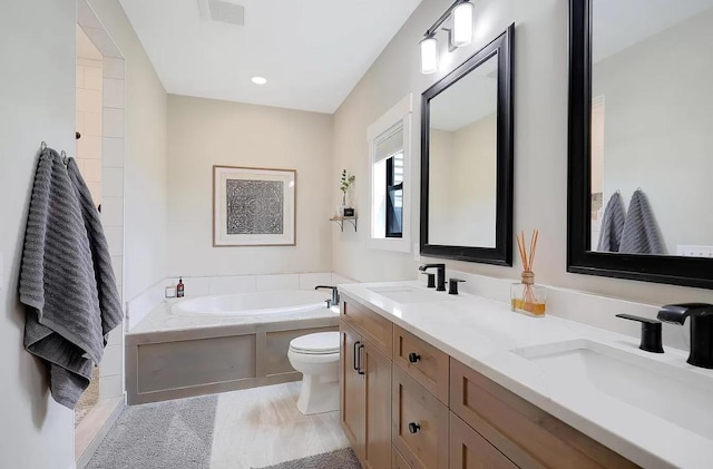 bathroom featuring a bath, double vanity, and toilet