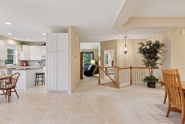 17462 Haralson Dr, Eden Prairie, MN 55347 - kitchen with white cabinetry, a center island, a kitchen breakfast bar, decorative backsplash, and decorative light fixtures